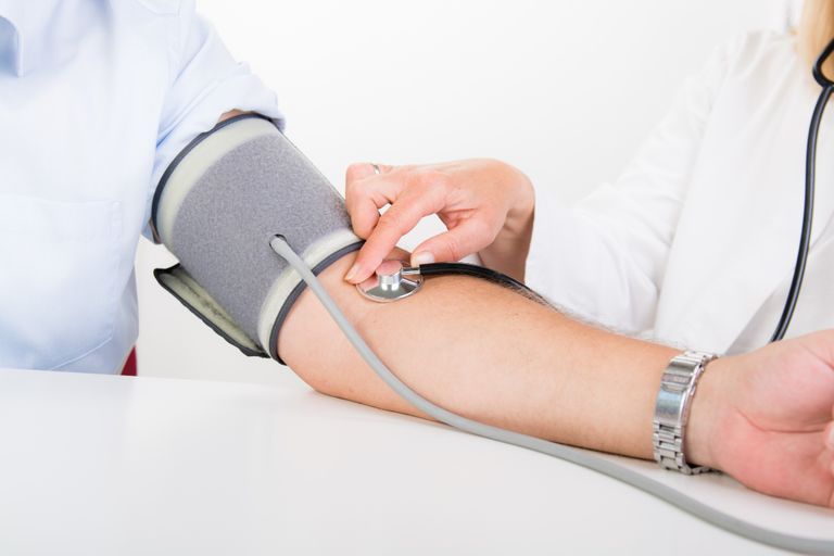 Blutdruck mit Hilfe einer Manschette und Stethoskop wird gemessen